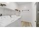 Well-lit laundry room featuring a side-by-side washer and dryer and ample shelving at 7122 Red Gulch St, North Las Vegas, NV 89084