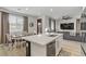 Open-concept kitchen and living room with modern lighting, dining table, and large windows with natural light at 7122 Red Gulch St, North Las Vegas, NV 89084