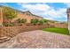 The backyard features low-maintenance artificial turf, a brick paver patio, and a retaining wall at 8257 Skye Peak St, Las Vegas, NV 89166