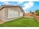 The backyard has a brick-paver patio, artificial turf, and a retaining wall with mature plants at 8257 Skye Peak St, Las Vegas, NV 89166