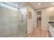 Modern bathroom featuring glass-enclosed shower, wood-look tile, and large window at 8257 Skye Peak St, Las Vegas, NV 89166