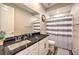 Bathroom featuring a mirror, sink, dark countertop, and shower with striped curtain at 8257 Skye Peak St, Las Vegas, NV 89166