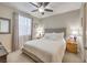 Bright bedroom with neutral walls, ceiling fan, carpet, and a large window at 8257 Skye Peak St, Las Vegas, NV 89166