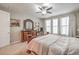 Bright bedroom with neutral walls, ceiling fan, carpet, and large windows at 8257 Skye Peak St, Las Vegas, NV 89166