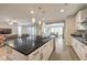 Open concept kitchen with granite island and stainless appliances flows seamlessly into the living and dining areas at 8257 Skye Peak St, Las Vegas, NV 89166