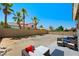 Large backyard patio with palm trees, an outdoor seating area, and blue skies at 8355 Cabin Peak St, Las Vegas, NV 89123