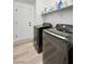 Convenient laundry room equipped with modern, dark washer and dryer units and overhead shelving at 8355 Cabin Peak St, Las Vegas, NV 89123