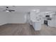 Open concept living space with wood-look floors, modern ceiling fan, and bright kitchen at 8410 Eldora Ave # 1045, Las Vegas, NV 89117