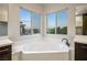Bright bathroom featuring a corner soaking tub and scenic view windows at 8647 Tortoise Canyon Ct, Las Vegas, NV 89148