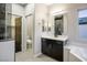 Bathroom featuring a dark vanity, soaking tub, and a separate toilet room at 8647 Tortoise Canyon Ct, Las Vegas, NV 89148