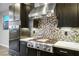 Kitchen with stainless steel appliances, decorative backsplash and modern range hood at 8647 Tortoise Canyon Ct, Las Vegas, NV 89148