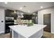 Open kitchen with an island, dark cabinets, stainless appliances, and statement backsplash at 8647 Tortoise Canyon Ct, Las Vegas, NV 89148
