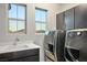 Convenient laundry room with sink, sleek cabinets, and modern washer and dryer units at 8647 Tortoise Canyon Ct, Las Vegas, NV 89148