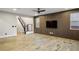 A bright and spacious living room with wood-look flooring, staircase, and a modern accent wall with a TV at 8647 Tortoise Canyon Ct, Las Vegas, NV 89148