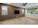 An open-concept living room features wood-look flooring, a modern accent wall, and ample natural light at 8647 Tortoise Canyon Ct, Las Vegas, NV 89148