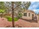 Backyard features artificial turf, rock landscaping, and house exterior at 8664 Frasure Falls Ave, Las Vegas, NV 89178