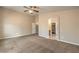 Large carpeted bedroom featuring a ceiling fan with an archway to an ensuite bathroom and walk-in closet at 8664 Frasure Falls Ave, Las Vegas, NV 89178