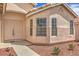 Close up of the exterior featuring a double door entrance, multiple windows, and desert landscaping at 8664 Frasure Falls Ave, Las Vegas, NV 89178