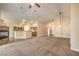 Spacious living room adjacent to the kitchen with high ceilings, a fireplace, and neutral carpet at 8664 Frasure Falls Ave, Las Vegas, NV 89178