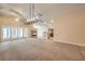 Spacious living room adjacent to the kitchen with high ceilings, a fireplace, and neutral carpet at 8664 Frasure Falls Ave, Las Vegas, NV 89178