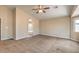 Primary carpeted bedroom showcasing an arched entrance to ensuite bathroom and large windows at 8664 Frasure Falls Ave, Las Vegas, NV 89178
