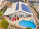 Stunning aerial view of a home with solar panels, pool, covered patio, and landscaped yard at 8911 Lansberry Ct, Las Vegas, NV 89147