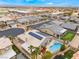 Expansive aerial view of a home featuring solar panels, a pool, a putting green, and playground in a vibrant community at 8911 Lansberry Ct, Las Vegas, NV 89147