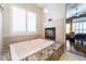 Luxurious bathroom with a soaking tub, fireplace, and window shutters, offering a serene retreat at 8911 Lansberry Ct, Las Vegas, NV 89147