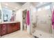 Modern bathroom featuring a glass-enclosed shower and cherry wood vanity with a granite countertop at 8911 Lansberry Ct, Las Vegas, NV 89147