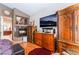 Spacious main bedroom with a fireplace, TV, wood floors, and classic wood furniture at 8911 Lansberry Ct, Las Vegas, NV 89147
