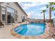 Inviting backyard pool with spa, rock features, and desert landscaping with tropical palm trees at 8911 Lansberry Ct, Las Vegas, NV 89147