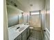 Bathroom with tile flooring, white bathtub with shower head, and gray vanity with a sink and mirror at 8990 Partridge Hill St, Las Vegas, NV 89148