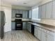Modern kitchen featuring gray cabinets, granite countertops, and stainless steel appliances at 8990 Partridge Hill St, Las Vegas, NV 89148