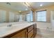 Bright bathroom featuring double sinks, a tub, shower and neutral tile flooring at 9019 Winchester Ridge St, Las Vegas, NV 89139