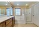 Bright bathroom featuring double sinks, a tub, shower and neutral tile flooring at 9019 Winchester Ridge St, Las Vegas, NV 89139