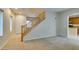 Bright living room with plush carpet, wood staircase, and access to the kitchen at 9019 Winchester Ridge St, Las Vegas, NV 89139