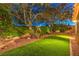 Serene backyard featuring lush greenery, mature trees, and an artificial lawn, offering a peaceful retreat at 9805 Turtle Walk Ave, Las Vegas, NV 89149