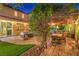 Charming backyard featuring a stone patio, outdoor seating, and mature trees at 9805 Turtle Walk Ave, Las Vegas, NV 89149