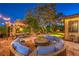 Backyard featuring a stone patio, outdoor seating, firepit, and mature trees at 9805 Turtle Walk Ave, Las Vegas, NV 89149