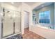 Bright bathroom featuring walk-in shower, double vanity sinks, and soaker tub with window at 9805 Turtle Walk Ave, Las Vegas, NV 89149