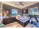 Cozy bedroom featuring window views, dark wood floors, and Raiders decor at 9805 Turtle Walk Ave, Las Vegas, NV 89149