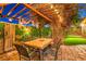 Inviting outdoor dining featuring string lights, stone patio, and mature trees at 9805 Turtle Walk Ave, Las Vegas, NV 89149