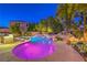 Inviting pool area with a rock waterfall feature, complemented by an outdoor kitchen and bar seating at 9805 Turtle Walk Ave, Las Vegas, NV 89149
