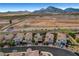 Aerial view of houses with mountain backdrop, manicured lawns, paver driveways, and tile roofs in a well-kept community at , Las Vegas, NV 89138