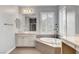 Bright bathroom featuring a soaking tub by shuttered windows and a long vanity at , Las Vegas, NV 89138