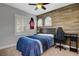 Comfortable bedroom featuring a sports jersey decoration, wooden accent wall, and natural light from shuttered windows at , Las Vegas, NV 89138