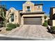 Charming two-story home with a brown garage door, landscaped yard and brick driveway at , Las Vegas, NV 89138