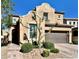 Charming two-story stucco home with brown garage door, landscaped yard and brick paver driveway at , Las Vegas, NV 89138