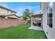 Spacious artificial grass backyard with extended covered patio and seating area at 10426 Mount Washington Ave, Las Vegas, NV 89166
