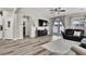 Open concept living room with modern light fixture, access to backyard and view to kitchen and dining area at 10426 Mount Washington Ave, Las Vegas, NV 89166